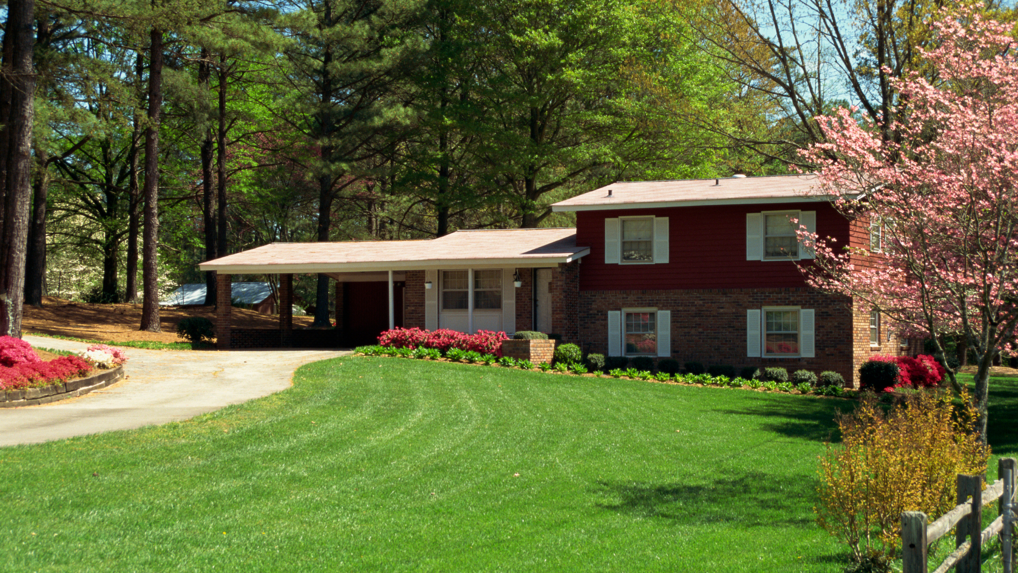 Mid-century tri-level split house with a brick facade and attached carport, typical of 1960s and 1970s construction